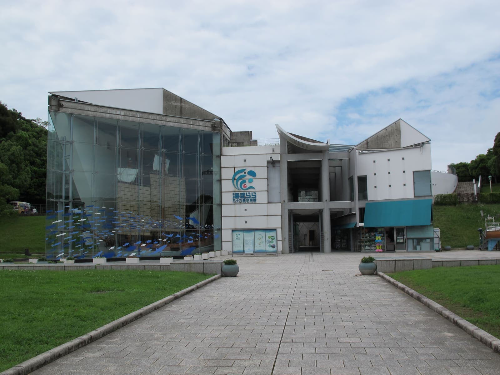 海きらら（九十九島水族館）の正面。ガラス張りの展示棟と、入口まで続く平らな石畳の園路