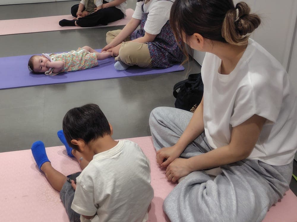 会場のマットの上で、赤ちゃんや子どもと一緒に親子講座に参加しているママたち